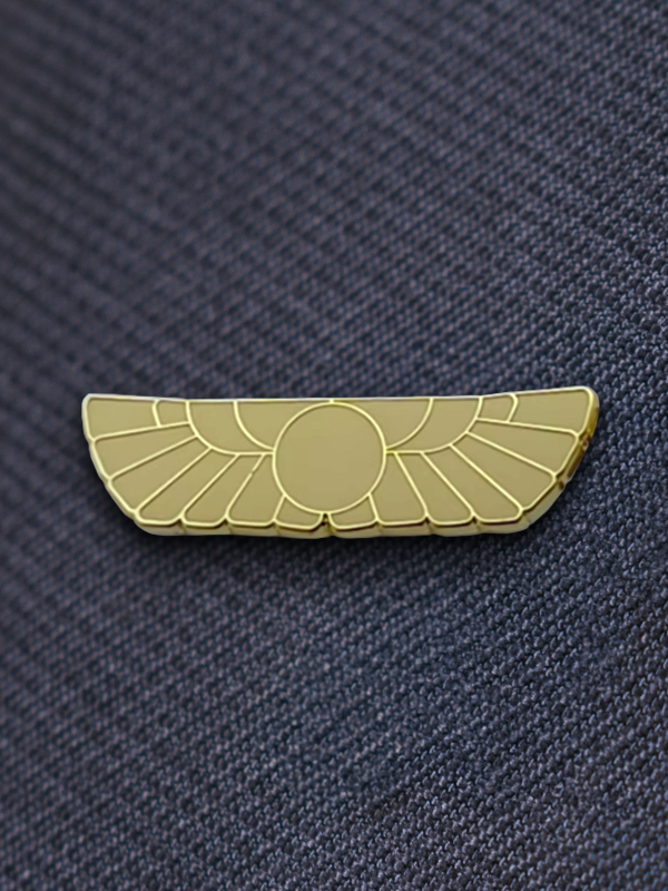 Un pin dorado esmaltado con las alas de Unity